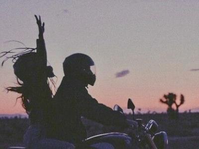 Хлопець і дівчина на мотоциклі на фоні заходу сонця