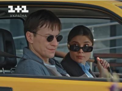 Головні герої - Паша та Софія, сидять у Софіїній жовтій машині. Вони обоє вдягнені у окуляри, що захищають від сонячного проміння. Паша, на передньому плані, якраз пристібається паском безпеки. Софія, позаду, за кермом, дивиться на нього.